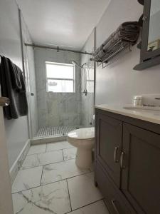 uma casa de banho com um chuveiro, um WC e um lavatório. em House w/ 3 bedrooms/pool/garden em Margate