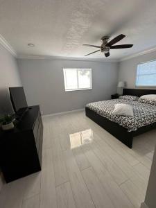 um quarto com uma cama e uma ventoinha de tecto em House w/ 3 bedrooms/pool/garden em Margate