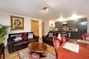 un soggiorno con mobili in pelle e tavolo di Inviting 9-Bed House in Aberdeen ad Aberdeen