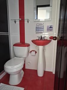 a bathroom with a toilet and a sink at Hotel Campestre El Triunfo in San Agustín