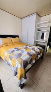 a bedroom with a bed with a checkered blanket on it at Senderos Apartment, Self Check- in, Airport SJO 5 MIN in Santiago Este