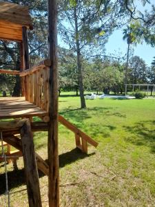 a wooden bench sitting on a pole in a park at Quinta La Alpina in Baradero