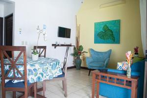 sala de estar con mesa, sillas y TV en Apartments-Villas Playa Potrero 1 en Potrero