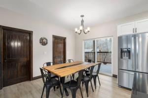 a dining room with a table and a refrigerator at Rock and Timber Lodge in Branson