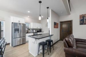 a kitchen with a refrigerator and a counter with stools at Rock and Timber Lodge in Branson