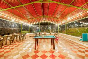 a ping pong table in a room with tables and chairs at Cabaña Tipo Glamping Savieza Life Experience in Nemocón