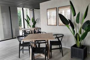 a dining room with tables and chairs and a potted plant at Apartamento Greta Río CalleCalle in Valdivia