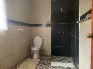a bathroom with a toilet and black and white tiles at Penn Rest -Apartment in Pennington