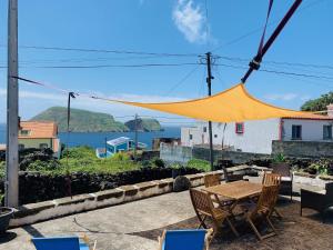 Una mesa y sillas con vista al mar. en Casa Avô São Miguel, en Angra do Heroísmo
