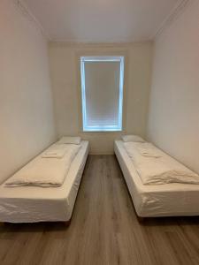 twee bedden in een kleine kamer met een raam bij Grunerløkka Apartments in Oslo