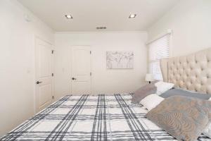 Dormitorio blanco con cama grande y cabecero grande en Perfect Suite near Universal Studios, en Los Ángeles