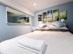 a bedroom with a white bed with four paintings on the wall at Skylight Room. in Lucan