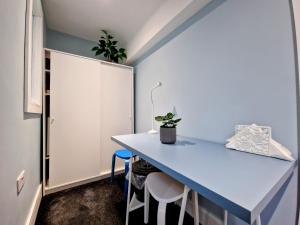 um pequeno quarto com uma mesa azul e cadeiras em Skylight Room. em Lucan