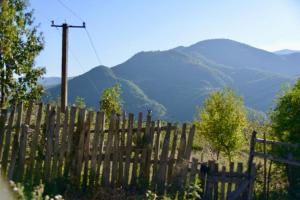 a wooden fence with mountains in the background at Shpija E AMEL (Sweet Guest House) 