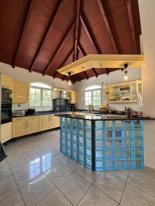 una gran cocina con armarios de madera y una gran isla en Guadeloupe Guesthouse, en Port-Louis