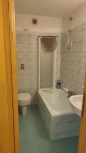 a bathroom with a tub and a toilet and a sink at Sasso Rosso Apartment in Folgarida