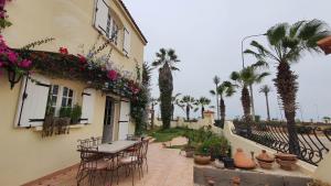un patio con mesa, sillas y palmeras en Lara House 1, en Agadir