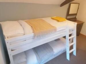 a white bunk bed with a yellow towel on it at The Old Barn, Cosy Townhouse in Leominster in Leominster