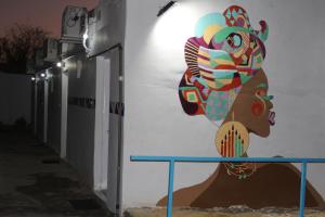un mural de una mujer al lado de un edificio en Nile View Guest House, en Asuán
