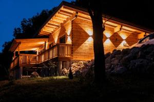 une grande maison en bois avec des lumières sur son côté dans l'établissement Romantikchalet, à Vorra