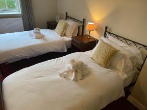 two beds with a stuffed animal sitting on top of them at The Priory Hotel in Louth