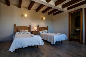 two beds in a room with wooden floors at Casa rural El Veredero in Castrojeriz