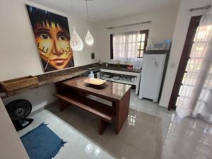 a kitchen with a large painting of a woman on the wall at Charmoso Chalé Triplex - Centro da Pipa in Pipa