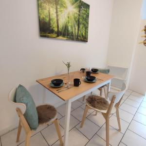 einen Holztisch mit 2 Stühlen, einem Tisch und einem Tisch in der Unterkunft Praktisch und Gut in der Goldstadt in Pforzheim