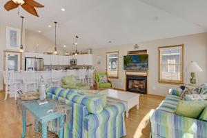 uma sala de estar com sofás e uma lareira em 7000 Serenity Sands Oceanfront em Nags Head