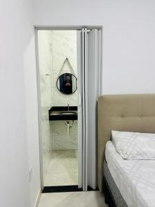 un hombre tomando una foto de un baño con espejo en Bela Casa Hostel, en Ji-Paraná