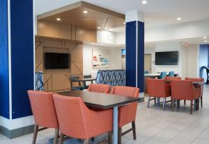 a dining room with orange chairs and a table at Holiday Inn Express Hotel & Suites Cedar Hill, an IHG Hotel in Cedar Hill