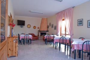 a dining room with tables and chairs and a fireplace at B&B Le Ginestre in Viggianello