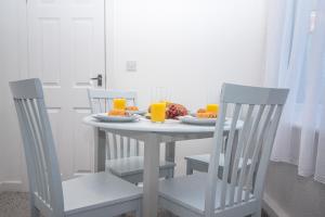 a table with two chairs and a table with food and orange juice at Alston House in Hartlepool