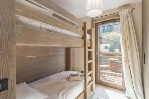 a bunk bed in a room with a window at Appartement du Cerf - Welkeys in Megève