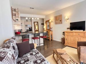 a living room with a couch and a kitchen at Hypercentre : Chaleureux T3 - 2 chambres + 2 SDB in Cauterets