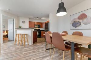 a kitchen and dining room with a wooden table and chairs at Light N Airy, Pool, Hot Tub, Pets, Ground Floor in Invermere