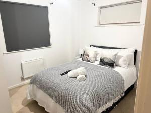 una camera da letto con un letto e due asciugamani di Secure parking 3 bedroom stylish house with garden a Manchester