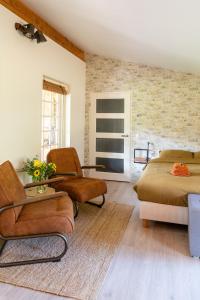 uma sala de estar com duas camas e duas cadeiras em Logies-Spier em Spier