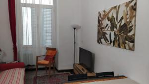 ein Wohnzimmer mit einem TV und einem Stuhl in der Unterkunft Iron Home in Genua