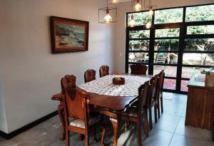 comedor con mesa de madera y sillas en Glenette Residence, en Ciudad del Cabo