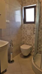 a bathroom with a toilet and a window at Apartments Jerko in Vrboska