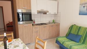 a kitchen with a table and a couch and a kitchen with a stove at Apartments Jerko in Vrboska +18 photos
