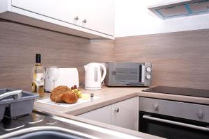 a kitchen with a counter with bread and a microwave at Alston House in Hartlepool