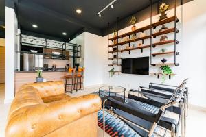 Una sala de estar con un sofá de cuero y un televisor. en NEW Perfect Location 24 Hours Security Free Parking, en Ciudad de México