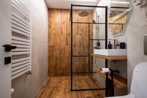 a bathroom with a shower and a wooden wall at MODERN PREMIUM APARTMENT 1 in Târgovişte
