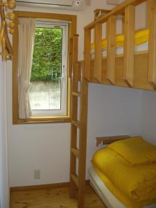 富士河口湖的住宿－Orange Cabin Inn far from station，一间卧室设有两张双层床和一扇窗户。