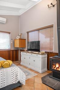 a bedroom with a fireplace and a bed and a television at Brisbane River Cabin in Mount Ommaney