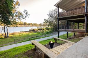 a picnic table with a candle on it next to a lake at Brisbane River Cabin in Mount Ommaney