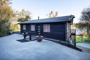 a small cabin with a large driveway in front of it at Brisbane River Cabin in Mount Ommaney