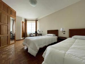 スクレにあるHOSPEDAJE SARABIAのベッド2台と窓が備わるホテルルームです。